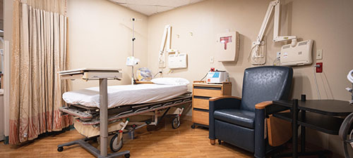 a hospital bed and chair with equipment